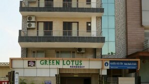 A multi-story building with the signage "GREEN LOTUS RESIDENCY".