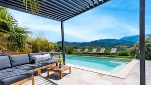 A covered outdoor area with a pool, lounge chairs, and a sofa. - Gite Les Aiguillans (Mérindol-les-Oliviers)