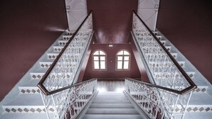 Una escalera con barandillas de metal ornamentadas y baldosas de suelo con diseños.
