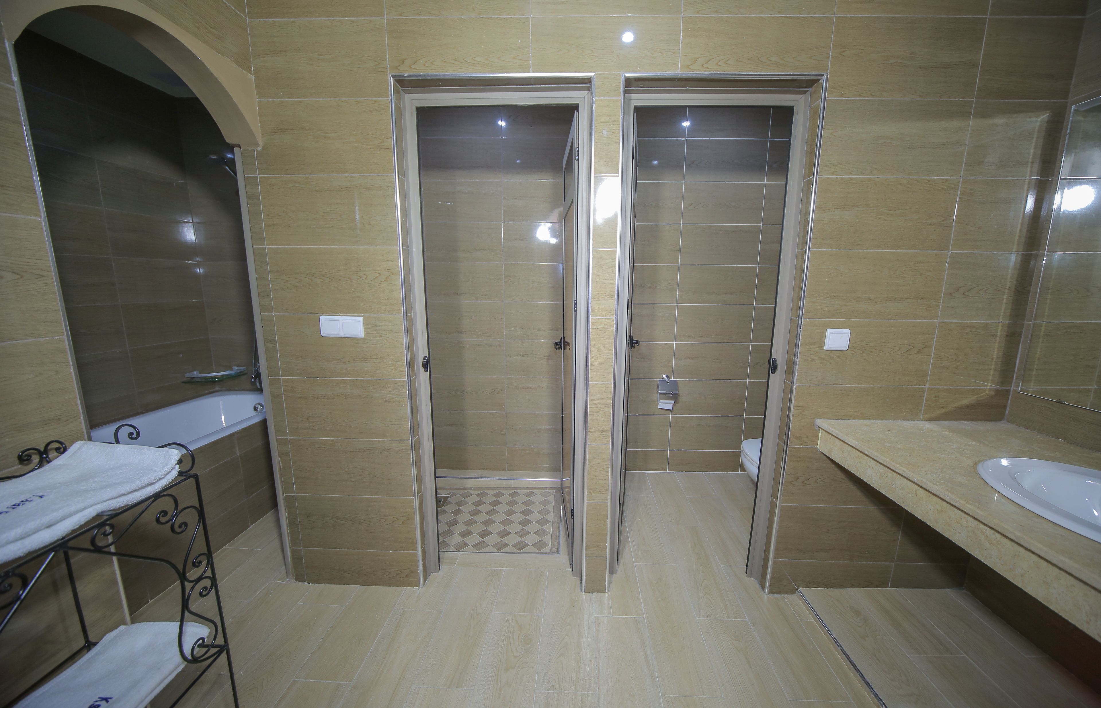 A bathroom with two glass-enclosed shower stalls, a sink, and a vanity.
