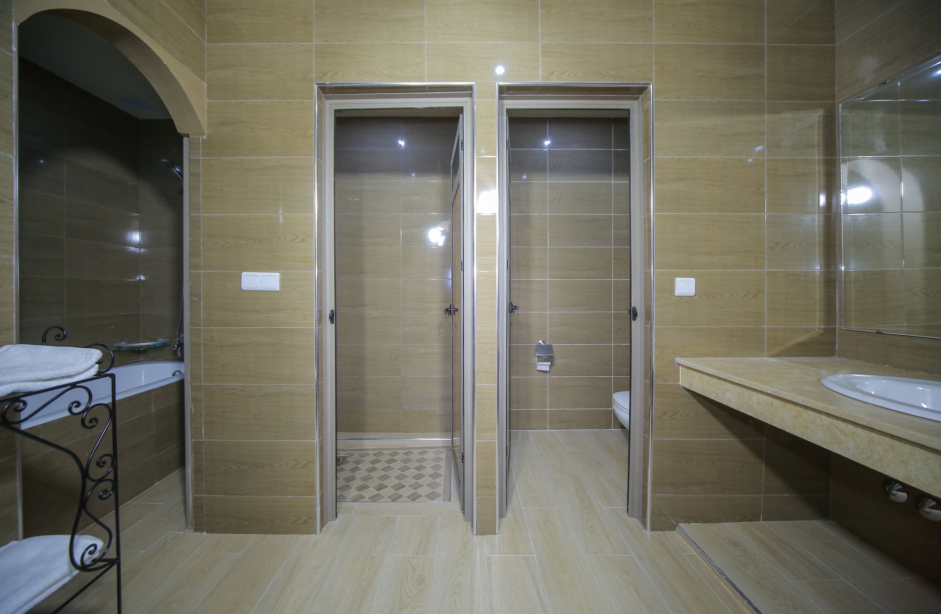 A bathroom with two doors, a sink, and a mirror.