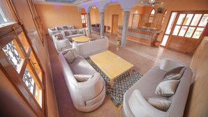 Amplia sala de estar con sofás, una mesa de centro y una barra decorativa.