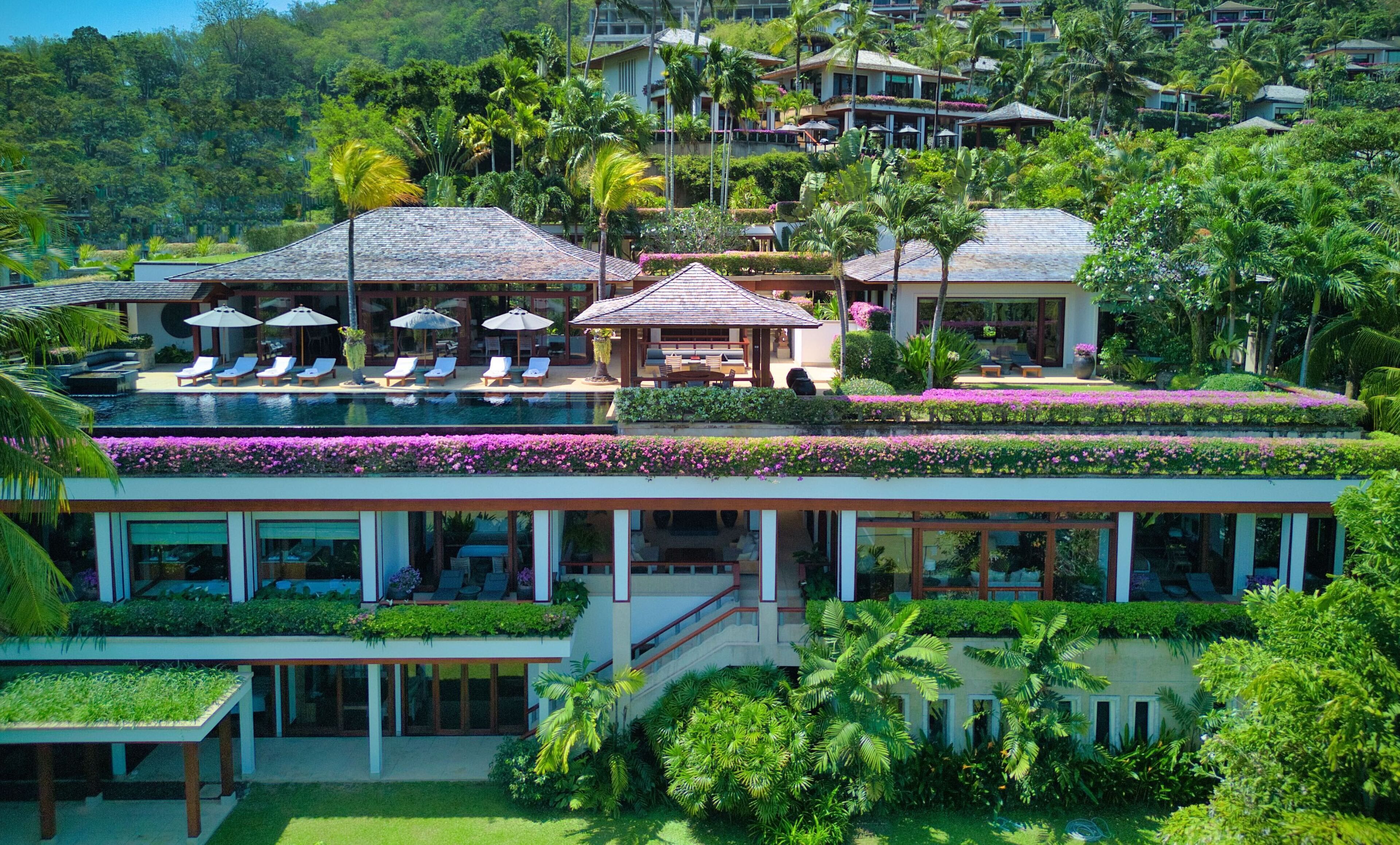 Un complexe hôtelier doté d’une piscine, de chaises longues et d’un patio couvert.