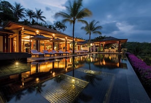 A luxurious resort with a swimming pool, lounge chairs, and palm trees. - Villa Chanjar- Kamala Beach (Kamala)