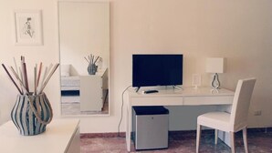 A modern office space with a desk, chair, computer, and a small trash bin. - B&B La Peonia (Reggio Calabria)