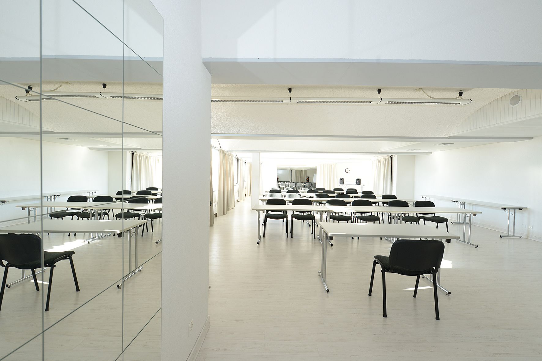 A conference room with tables and chairs arranged for meetings.