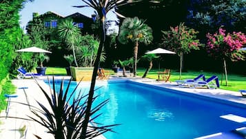 Piscine extérieure, parasols de plage, chaises longues