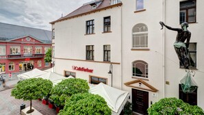 Ein Gebäude mit einem Café namens CafeHarber, einer Statue und einem roten Gebäude mit einem Schild.