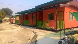 A two-story building with a red facade, green railings, and a covered porch area. - SiBamboo 2 (Chiang Rai)
