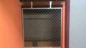 A room with a metal window grille, orange walls, and patterned flooring. - SiBamboo 2 (Chiang Rai)