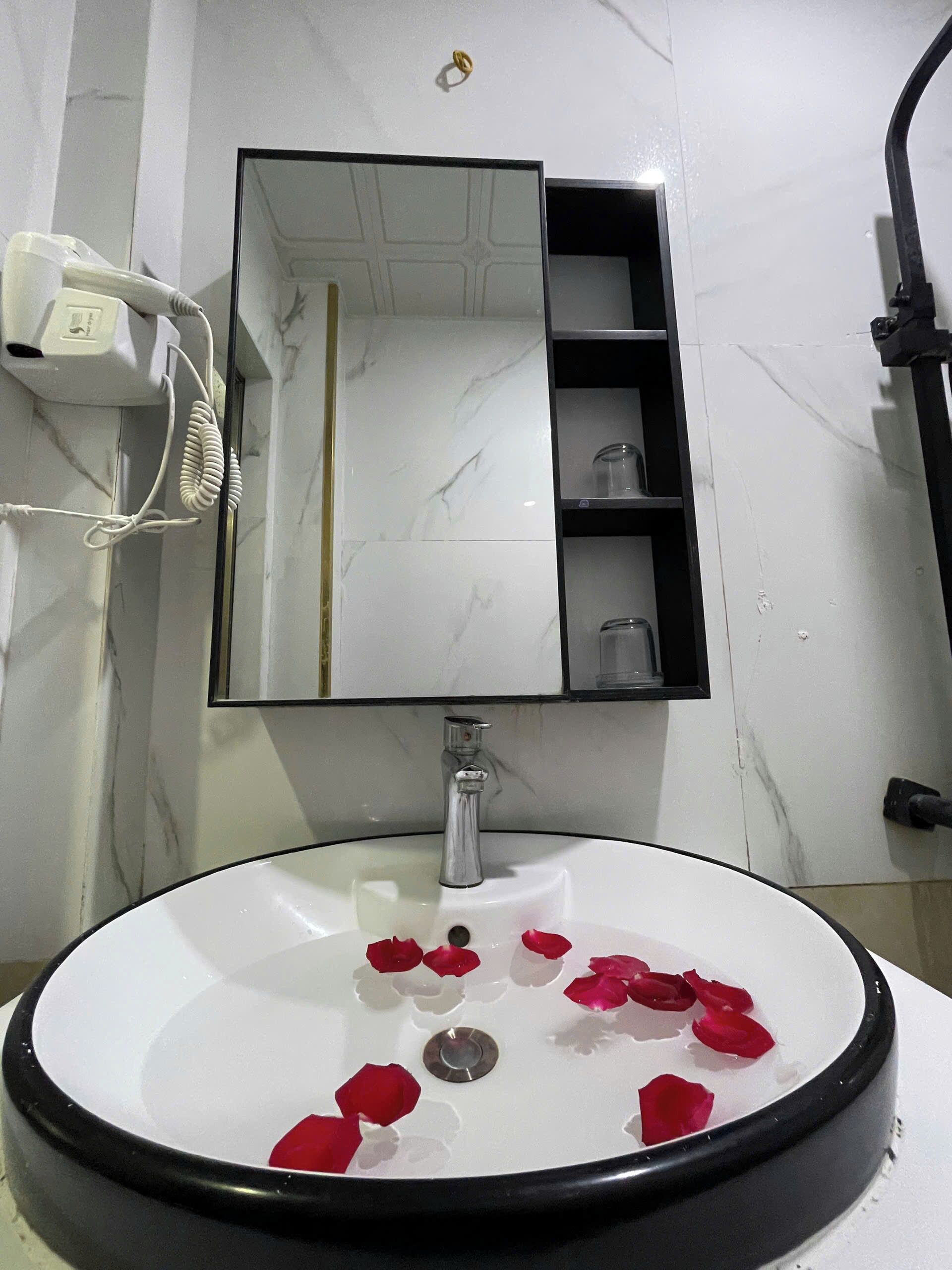 A bathroom with a white sink, a mirror, and a towel rack.