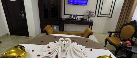 Una habitación de hotel con cama, televisión, escritorio y silla.