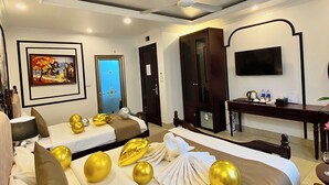 A hotel room with two beds, a ceiling fan, a painting, a TV, and a desk with a coffee pot. - Nam Cuong X Hotel (Hanoi)