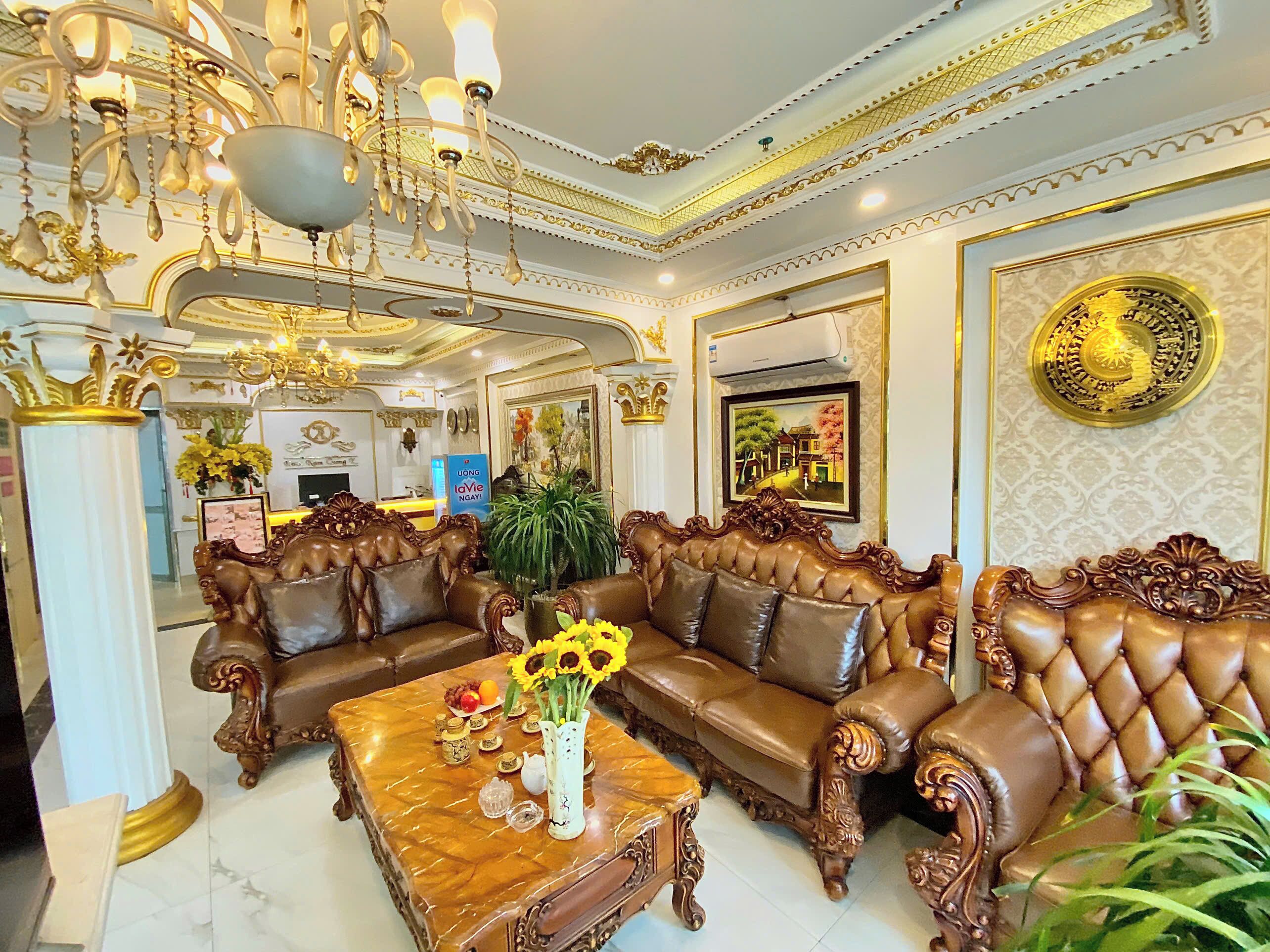 A luxurious living room with ornate furniture, a chandelier, and decorative wall art.