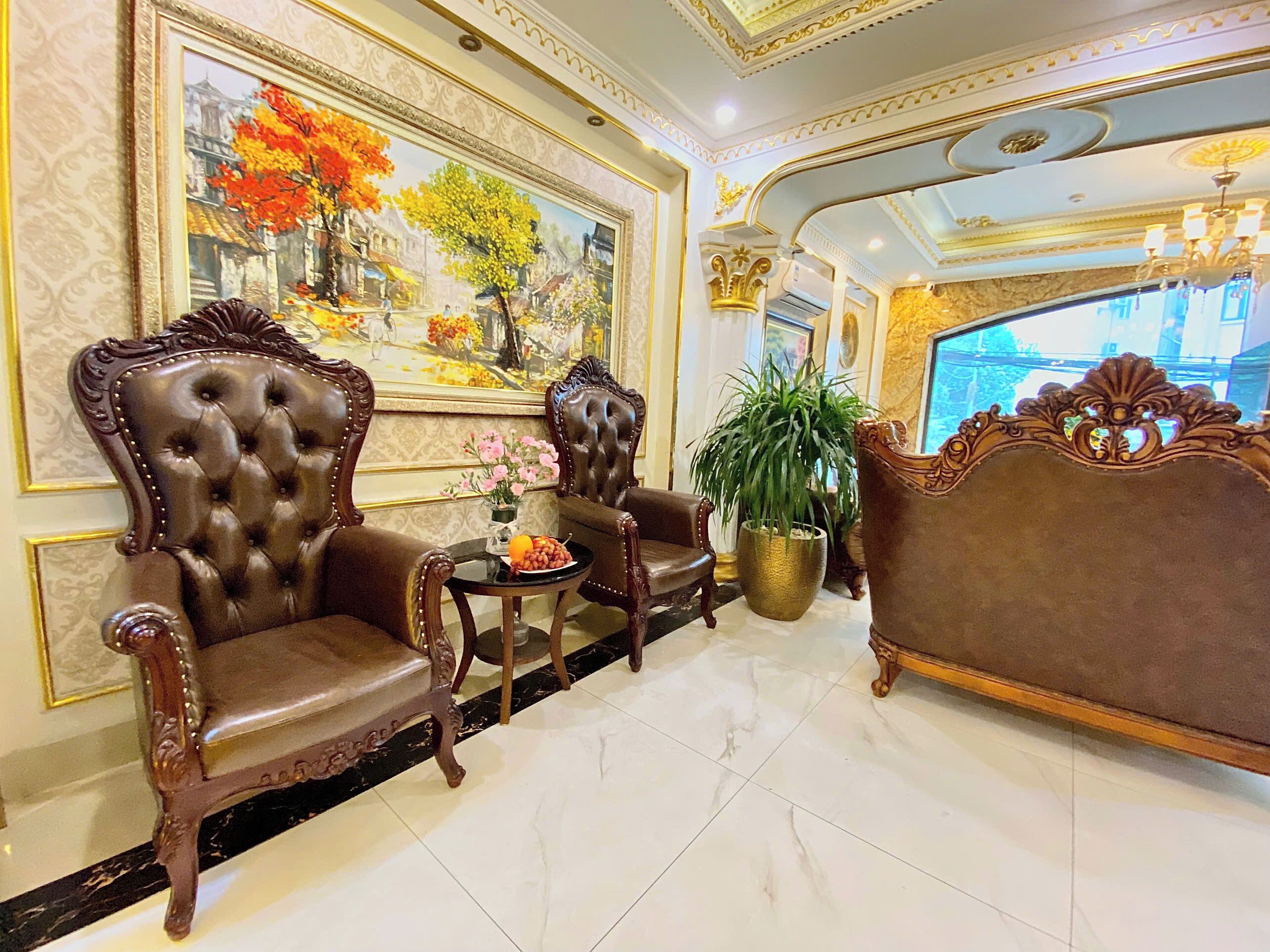 A luxurious lobby with ornate furniture, a large painting, and a chandelier.