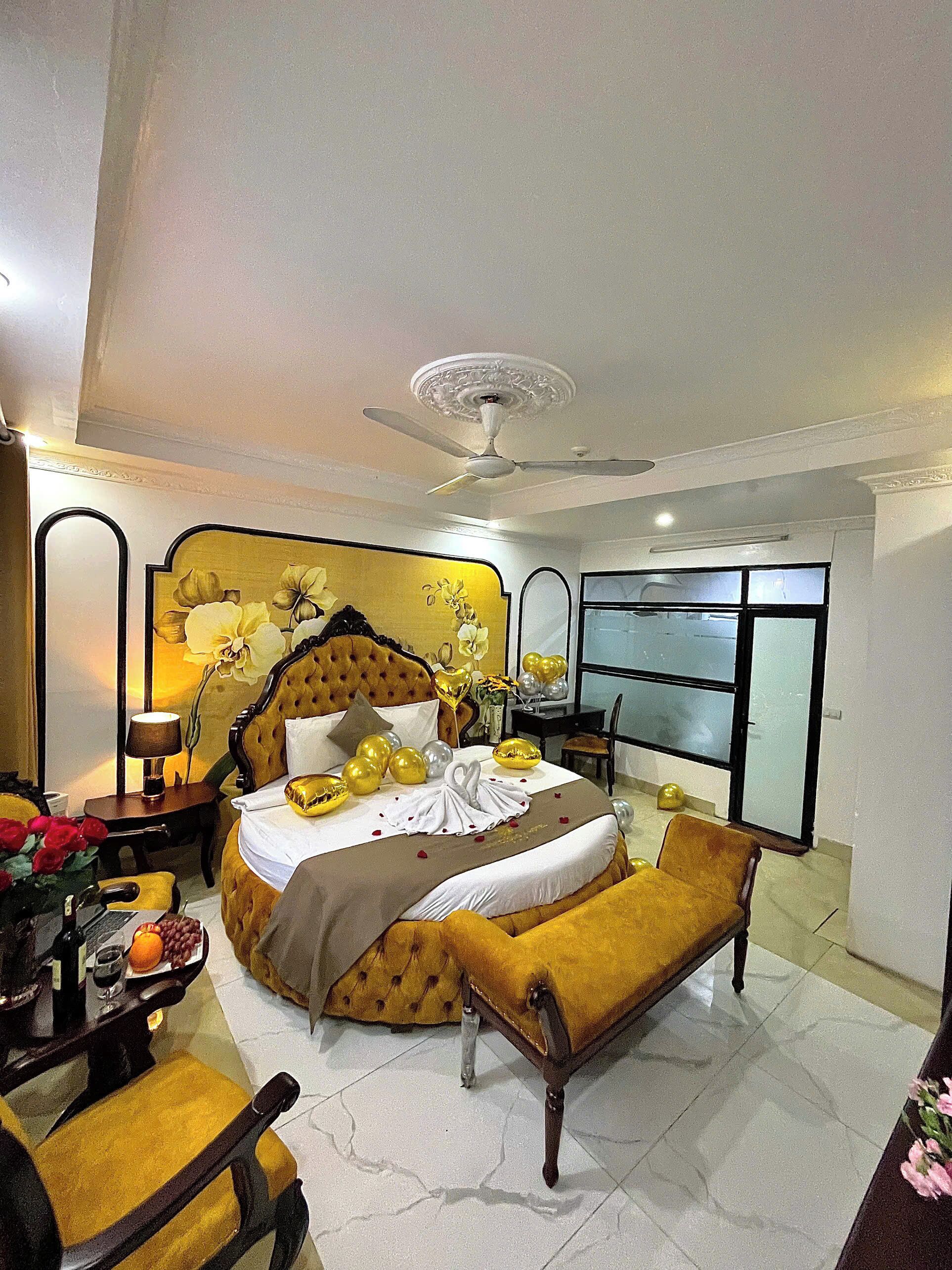Habitación de hotel con una cama grande, un escritorio con lámpara, una silla y vistas al exterior a través de una ventana.