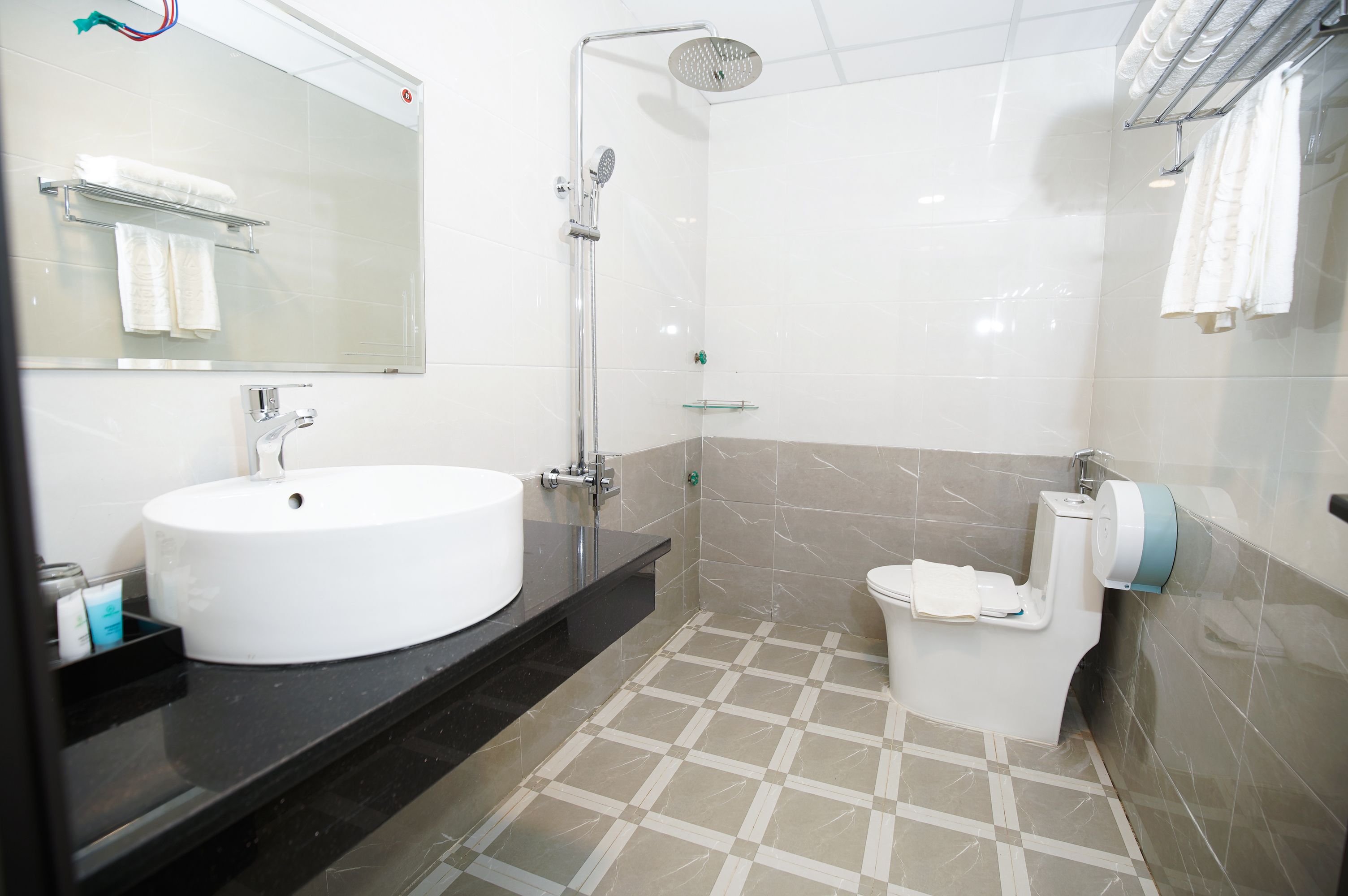 Un baño moderno con un lavamanos grande, una cabina de ducha de vidrio y un inodoro.