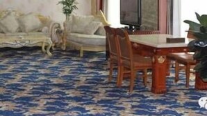 A hotel room with a dining table, chairs, a sofa, a television, and a large window. - Balin Hotel (Chifeng)