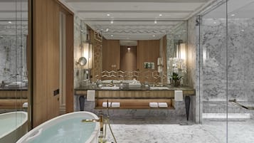 A modern bathroom with a freestanding bathtub, dual sinks, and a large mirror.