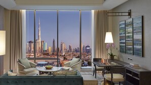 A modern hotel room with a large window offering a city skyline view, a cozy seating area, and a dining table. - Mandarin Oriental Jumeira, Dubai (Dubai)