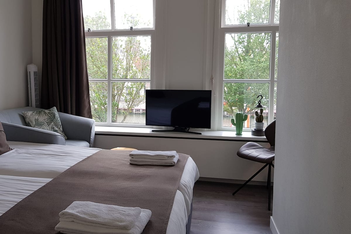 Habitació d'hotel amb dos llits, una televisió i una taula amb una cadira.