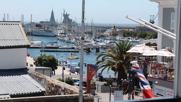 Un puerto deportivo con barcos, un barco grande y un restaurante llamado 'HEATHER ART GALL'.