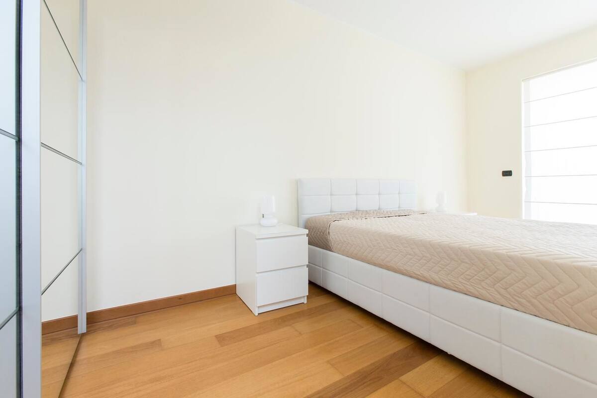 Ein Schlafzimmer mit einem Bett, einem Nachttisch und einem Kleiderschrank.