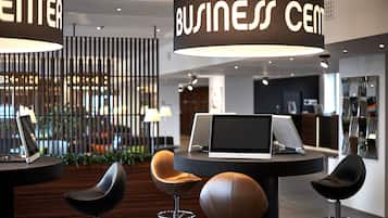 A modern business center with a reception desk, a laptop, and contemporary chairs.