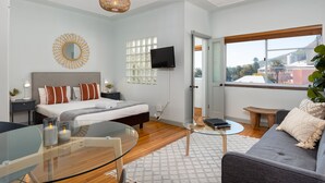 Un dormitorio moderno con cama, mesita de noche y una mesa de centro de vidrio.
