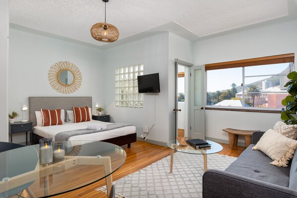 A modern bedroom with a bed, bedside table, and a glass coffee table.