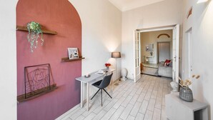 A modern interior with a desk, chair, and a red archway. - Apartments Florence - Ghibellina Loft (Firenze)