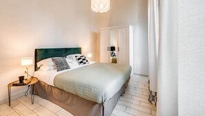 A neatly arranged bedroom with a bed, bedside table, lamp, and a wardrobe. - Apartments Florence - Ghibellina Loft (Firenze)