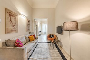 A modern living room with a sofa, a coffee table, a lamp, and framed artwork on the walls.