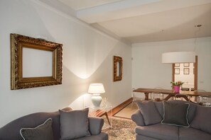 A living room with two sofas, a coffee table, a lamp, and two framed pictures on the wall.