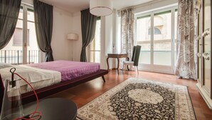 Una camera da letto con un letto, una scrivania, una sedia, una lampada e vista sull'esterno.