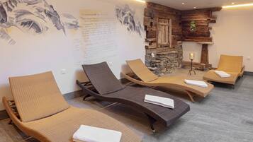 Une salle de spa comprenant quatre fauteuils, un mur en pierre et une fresque murale.