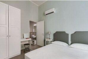 Une chambre à coucher avec un lit, un bureau, une chaise et une armoire.