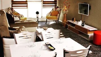 Deluxe Suite | Living area | 107-cm LCD TV with satellite channels, TV