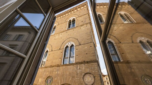 Un edificio alto e histórico con ventanas de arco y detalles de piedra elaborados.