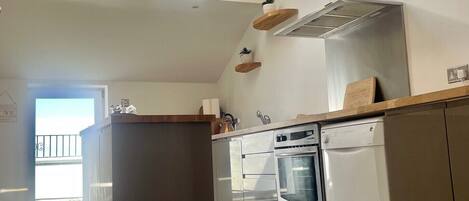 A modern kitchen with skylights, a central island, and built-in appliances.
