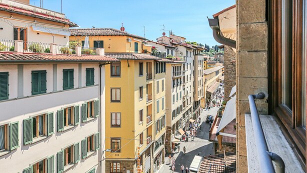 A multi-story building with balconies, a street below, and a clear sky. - Apartments Florence - Santa Maria Balcony (Firenze)