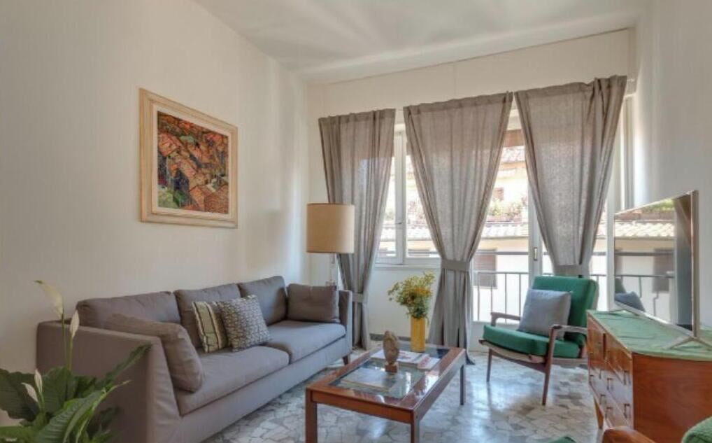 A living room with a sofa, a coffee table, a chair, a lamp, and a painting on the wall.