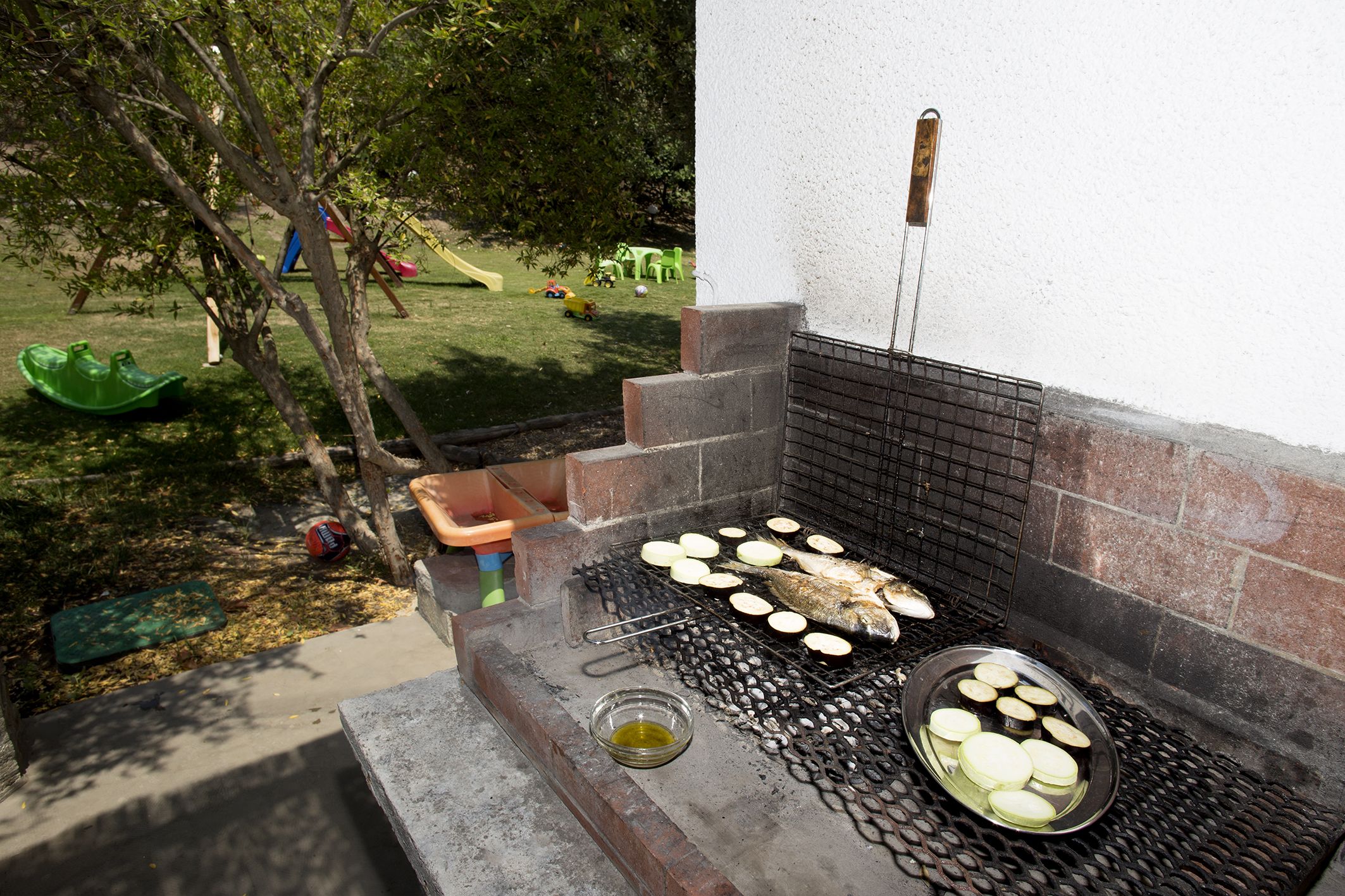 Ein Grill im Freien mit Fisch und Gemüse beim Kochen.