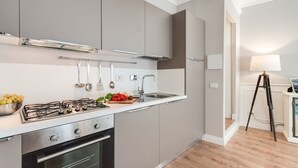 Una cocina moderna con armarios grises, una estufa de acero inoxidable y un lavabo.