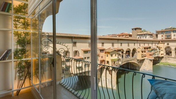 Un balcón con vista a un río y edificios históricos.