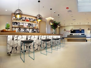Eine moderne Bar mit Wandverkleidung, Barhocker und Pendelleuchten.