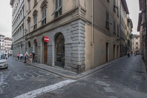A street with a building featuring a 'STOP' sign, stone facade, and arched windows. - Apartments Florence - Gemma Via del Moro (Firenze)