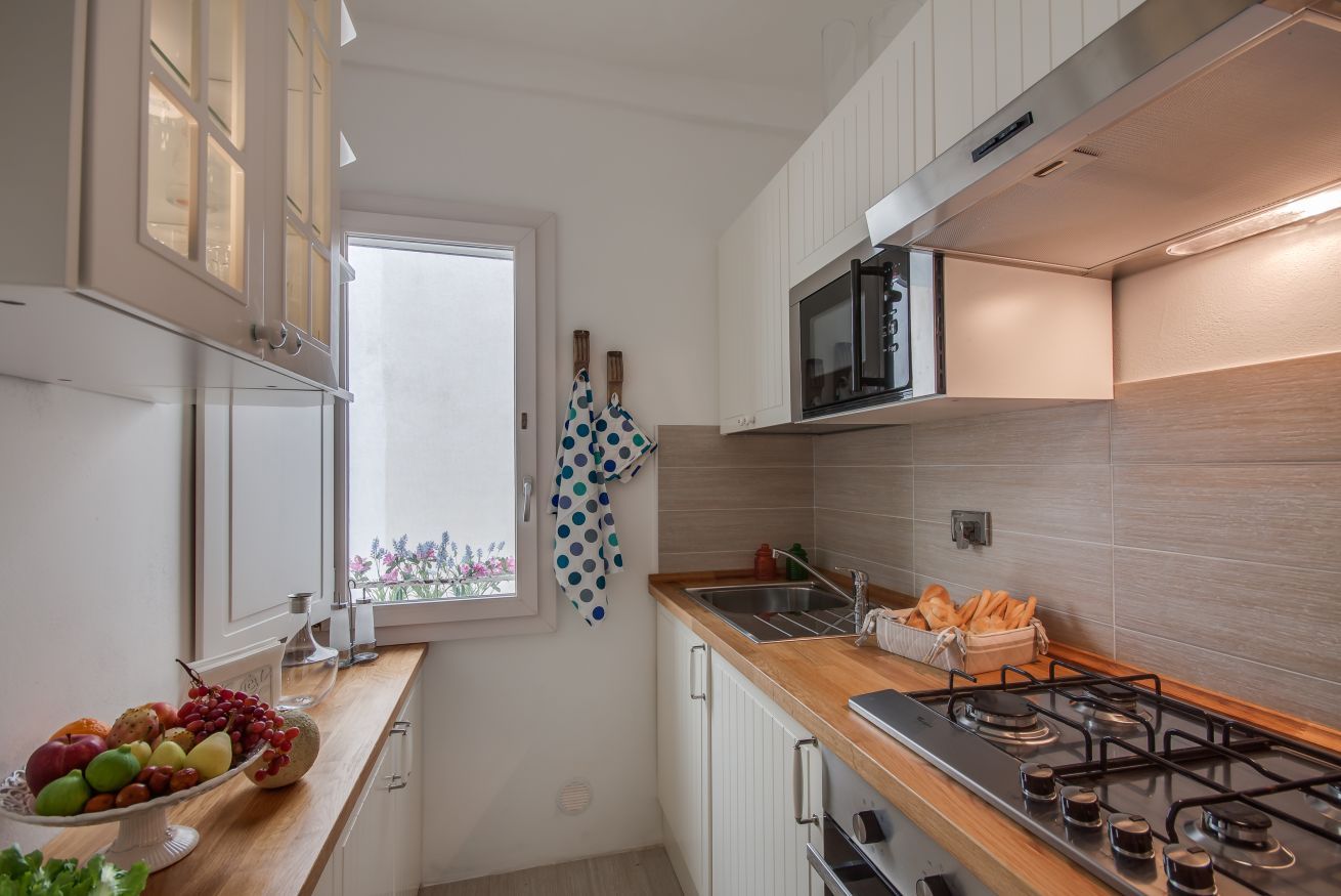 Una cocina moderna con estufa a gas, microondas y ventana con vistas.