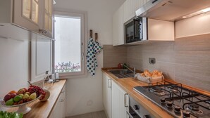 Une cuisine moderne équipée d’une cuisinière à gaz, d’un four à micro-ondes et d’une fenêtre offrant une belle vue.