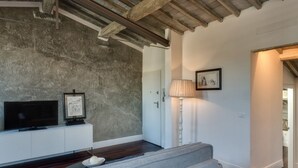 A living room with a television, a framed picture, a lamp, and a sofa. - Apartments Florence - Beautiful Terrace Serragli (Firenze)